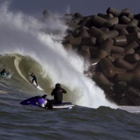 テトラポッドと波とサーファー